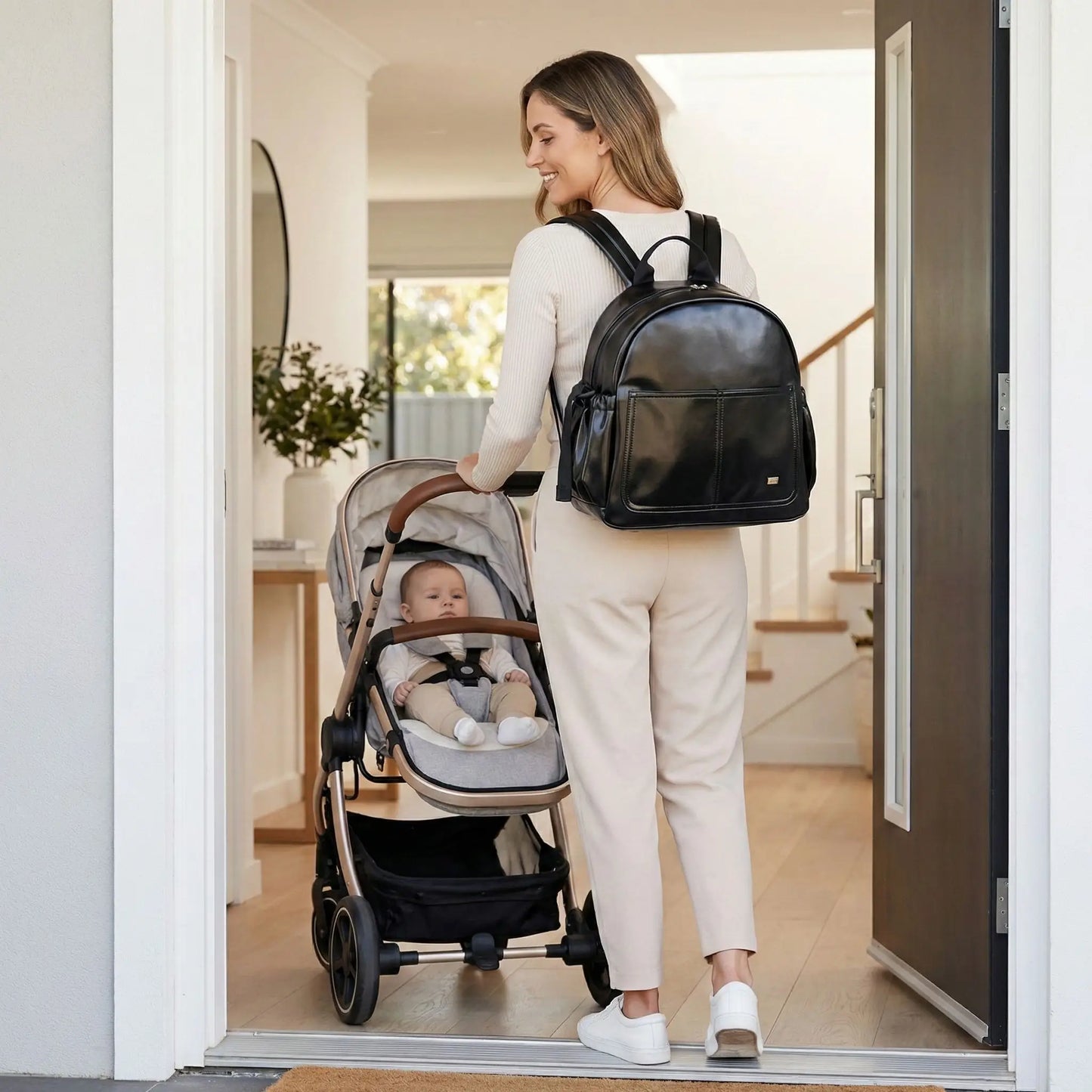 Femme portant un sac a dos a langer grande capacite noir au style moderne et structure