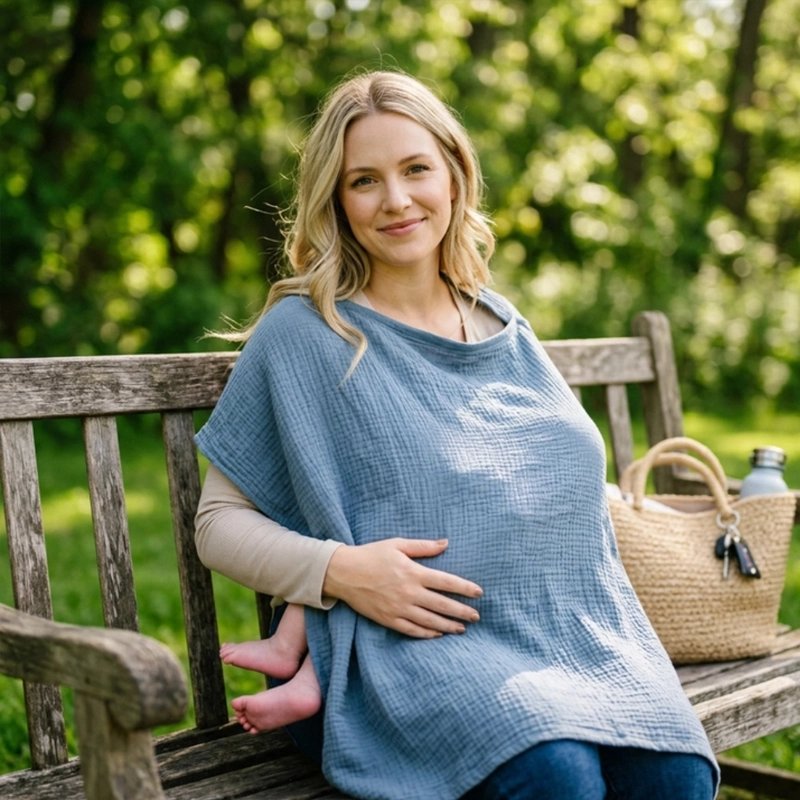 Cape d'allaitement bleue portée par une maman avec bébé lors d'une promenade
