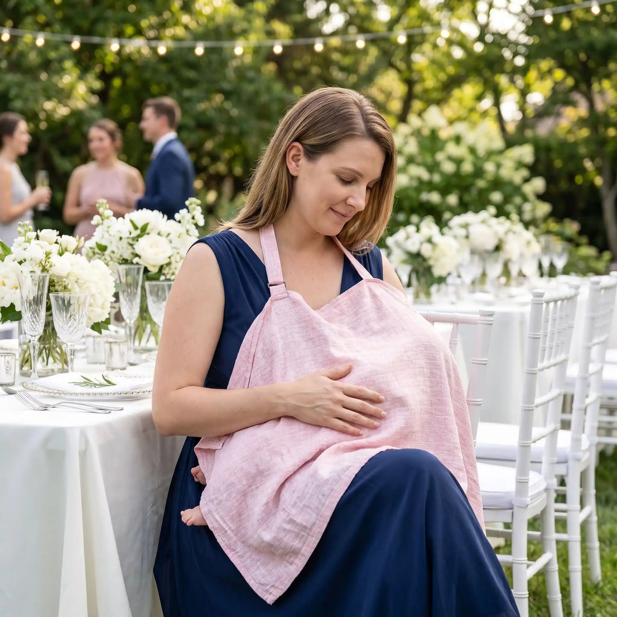 Cape d'allaitement portée par une maman avec bébé lors d'un mariage en extérieur