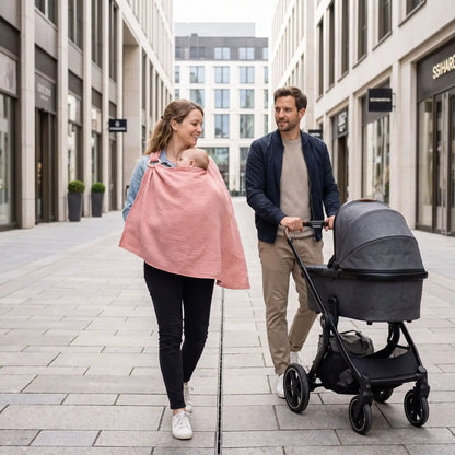 Cape d'allaitement portée par une maman lors d'une promenade en famille avec poussette