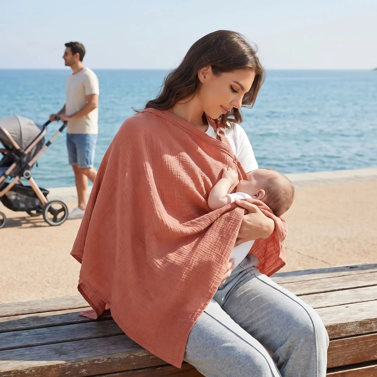 Cape d'allaitement portée par une maman avec bébé lors d'une sortie au bord de la mer