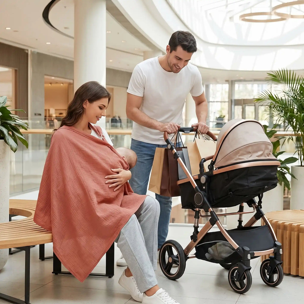Cape d'allaitement utilisée par une maman avec bébé dans un centre commercial près de la poussette