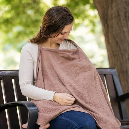 CCape d'allaitement marron portée par une maman assise avec bébé en extérieur