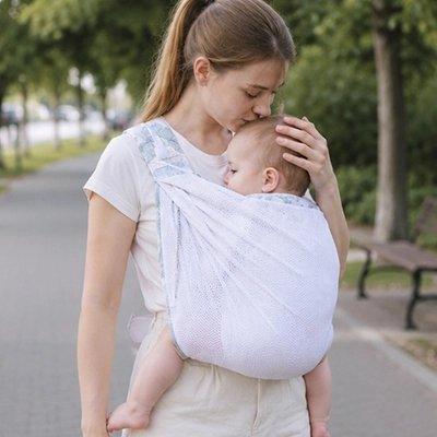 Echarpe de portage blanche permettant de porter bébé en position physiologique contre sa maman