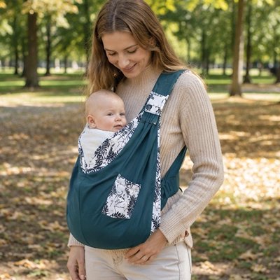 Echarpe de portage vert avec bébé en promenade dans un parc offrant confort et maintien