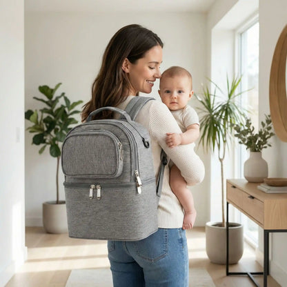 maman portant sac isotherme bebe gris au dos avec bebe dans les bras