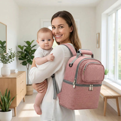 maman portant sac isotherme bebe rose au dos avec bebe dans les bras