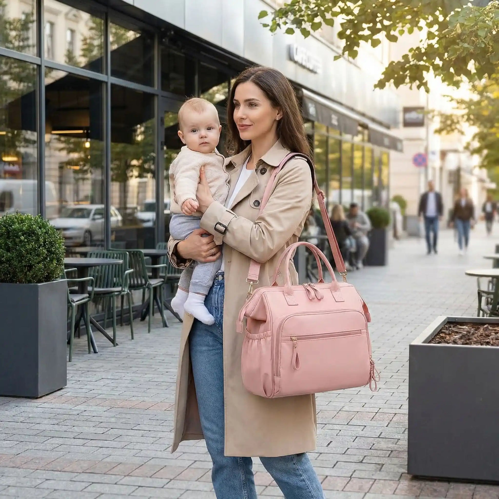 maman tenant bebe en bras avec sac a langer bebe pour sorties quotidiennes pres dun restaurant