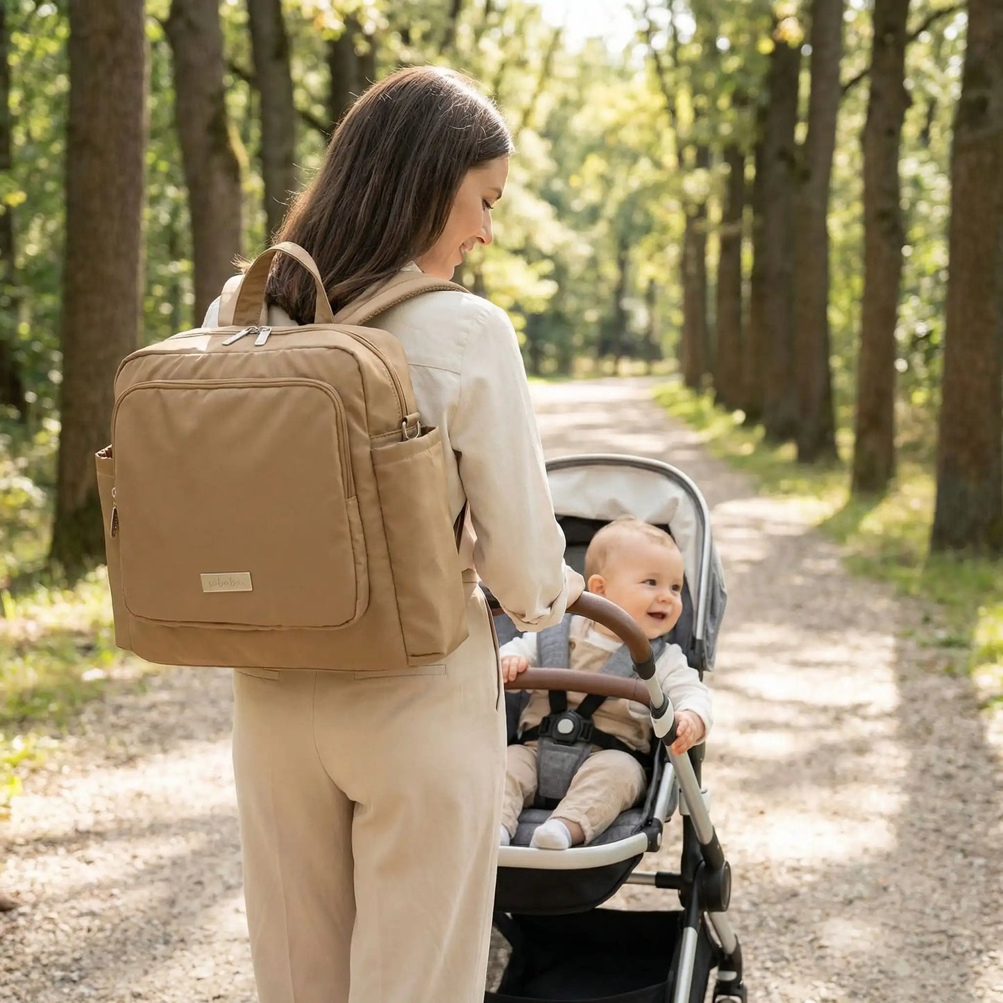 maman et bebe marchant dans une allee avec sac a langer bebe multifonction couleur creme