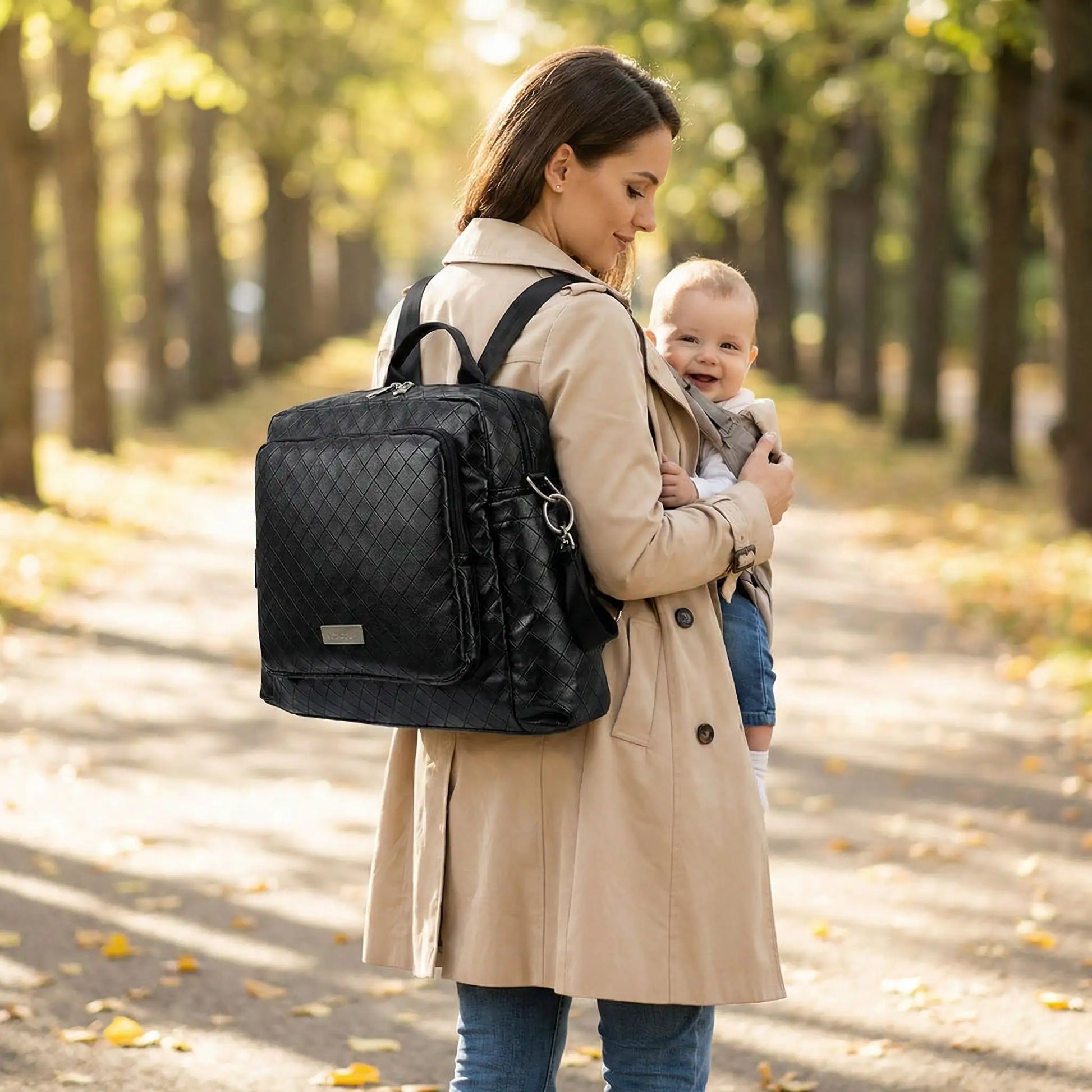 maman et bebe marchant dans une allee avec sac a langer bebe multifonction couleur noir