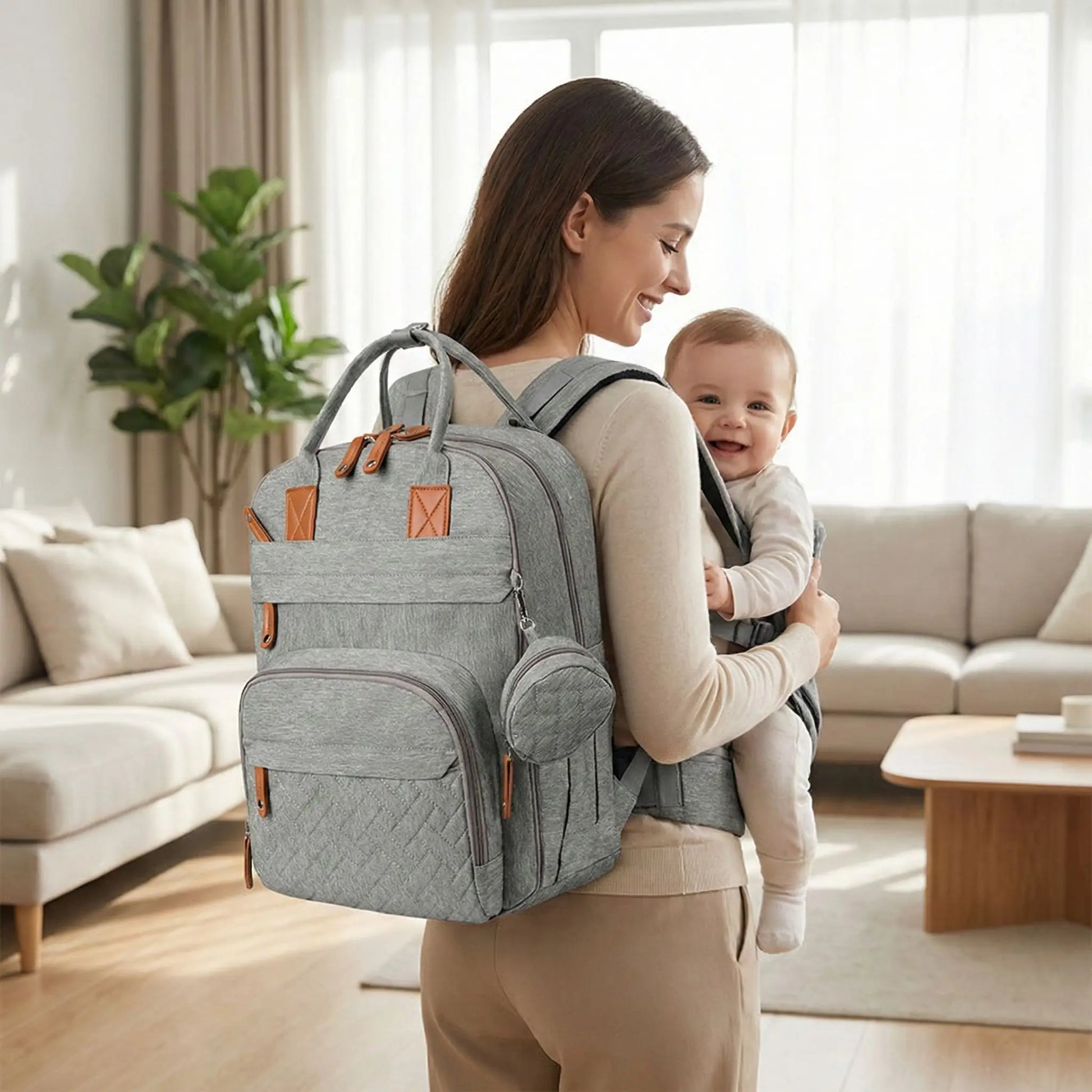 sac a dos a langer bebe gris porte par maman avec porte bebe dans un salon lumineux