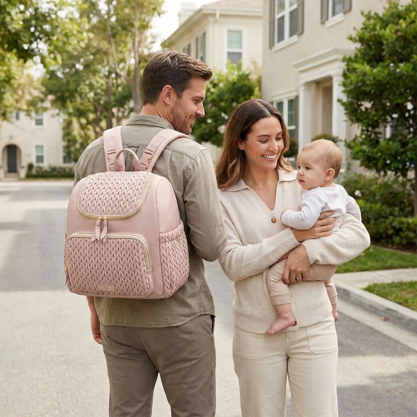 Sac a dos a langer bebe rose porte par papa lors dune promenade familiale en quartier residentiel