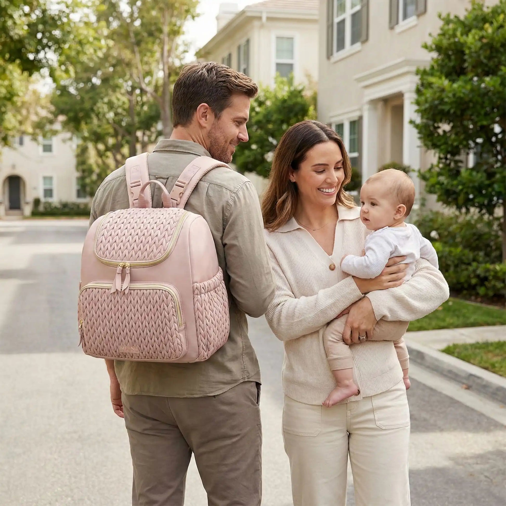 Sac a dos a langer bebe rose porte par papa lors dune promenade familiale en quartier residentiel