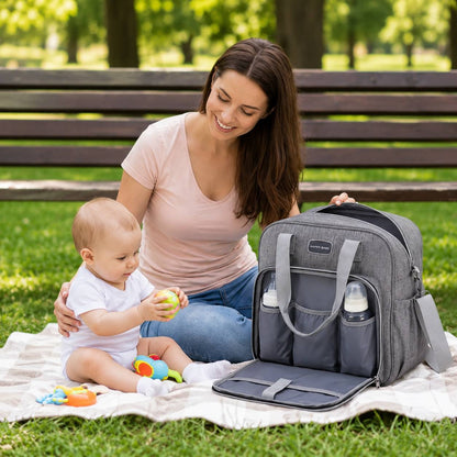 Sac a langer avec tapis de change gris utilisé lors d'un pique-nique avec bébé
