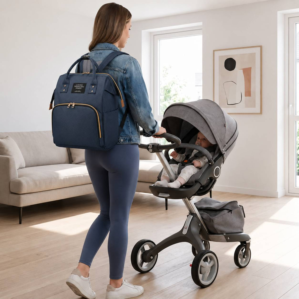 Maman portant un sac a langer bebe bleu tout en promenant son enfant en poussette