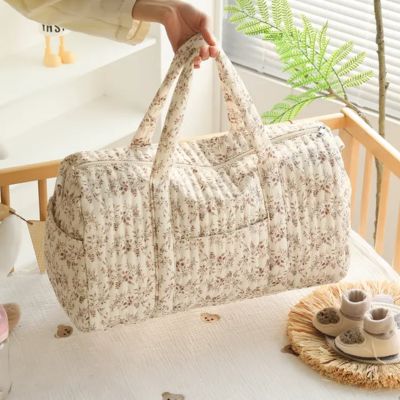 Sac a langer bebe grande capacite modele floral pose en interieur lumineux