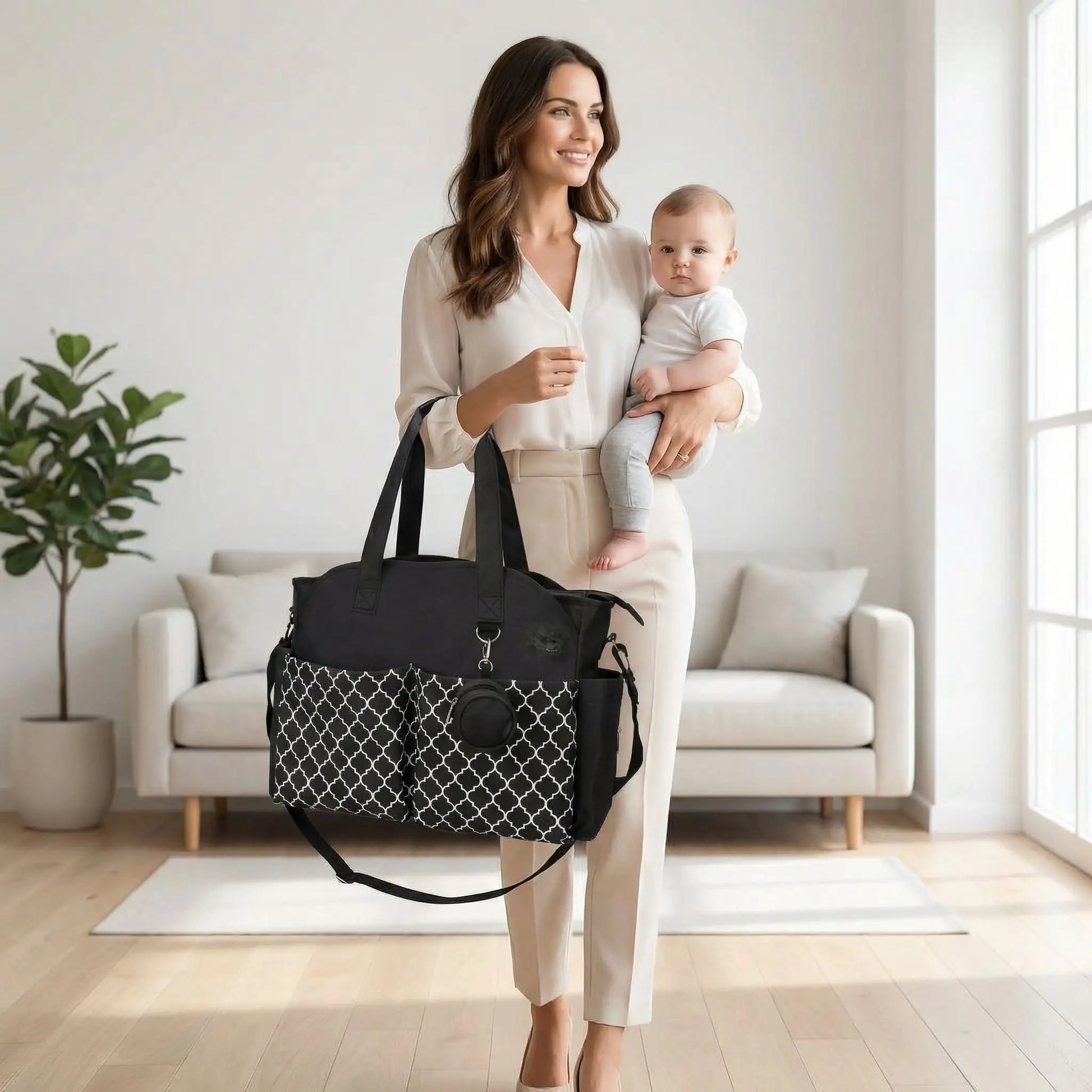 Sac a langer bebe noir structure porte a la main par une maman elegante prete a sortir avec son bebe