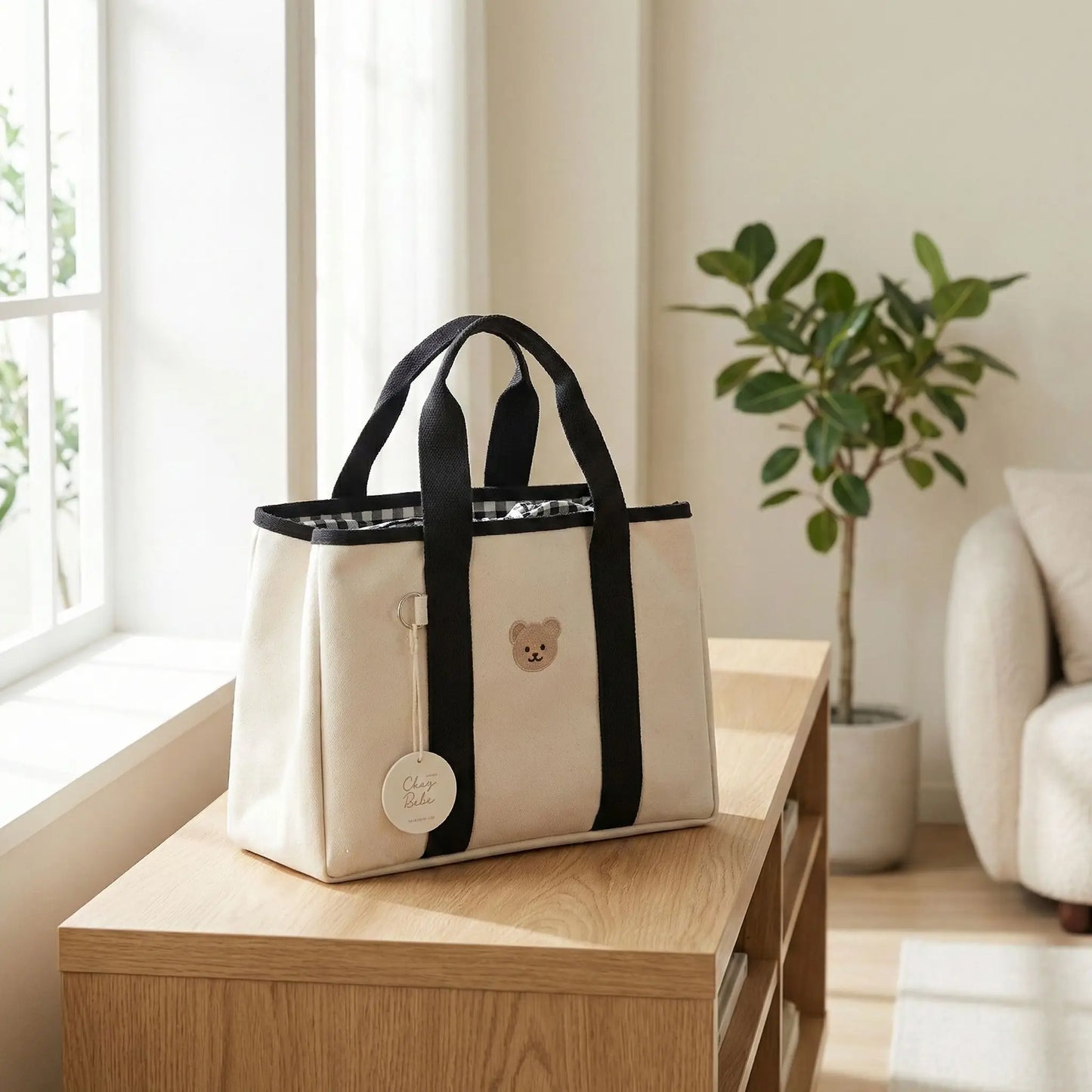 sac a langer portable compact noir et blanc pose seul sur console en bois clair