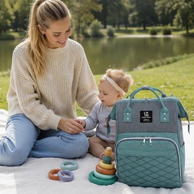 Sac a langer utilisé par une maman lors d'une sortie avec son bébé dans un parc
